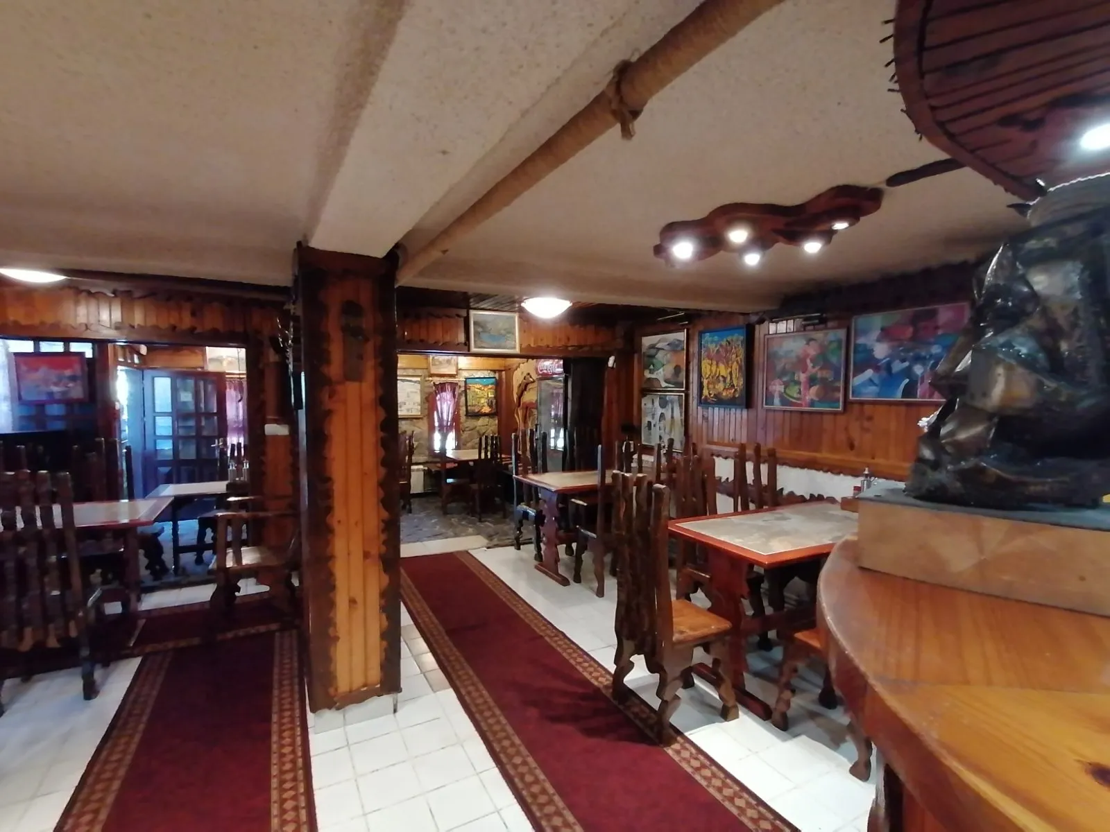 The tavern hall with wooden tables and paintings